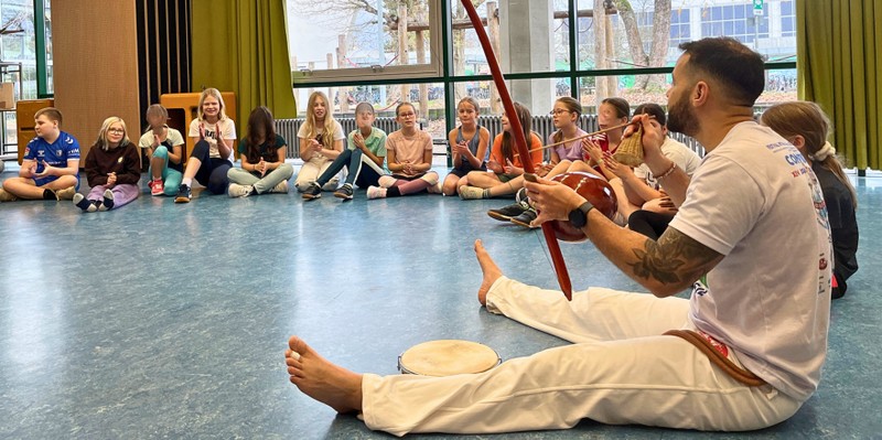 Capoeira1 Trainer mit Kindern 5c im Kreis auf dem Boden